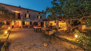 Un edificio de piedra con terraza y mesa de billar.