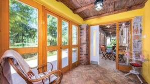 A room with large windows, a wooden ceiling, and a brick wall. - Beautiful home in Nedescina (Nedescina)