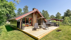 A modern house with a wooden deck, outdoor seating, and a large window overlooking the yard. - 2 bedroom gorgeous home in Silkeborg (Silkeborg)
