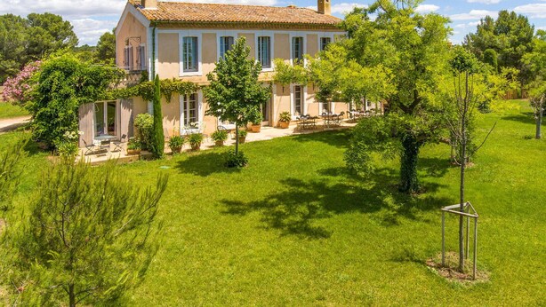 A large, single-story house with a tiled roof, surrounded by a well-maintained lawn and various trees. - Lovely home in Béziers (Béziers)