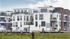 Un immeuble moderne à plusieurs étages, doté de balcons, d’un toit plat et d’une façade plane.