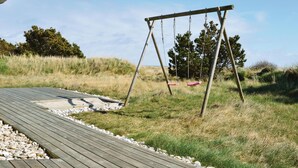 Een houten terras met een schommel.
