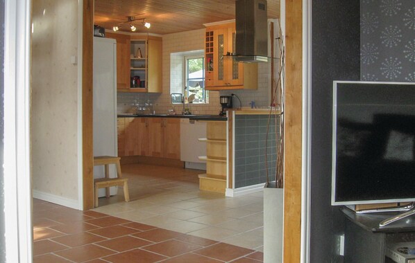 A kitchen with wooden cabinets, a tiled floor, and a built-in stove. - 4 bedroom awesome home in Lärbro (Lärbro)