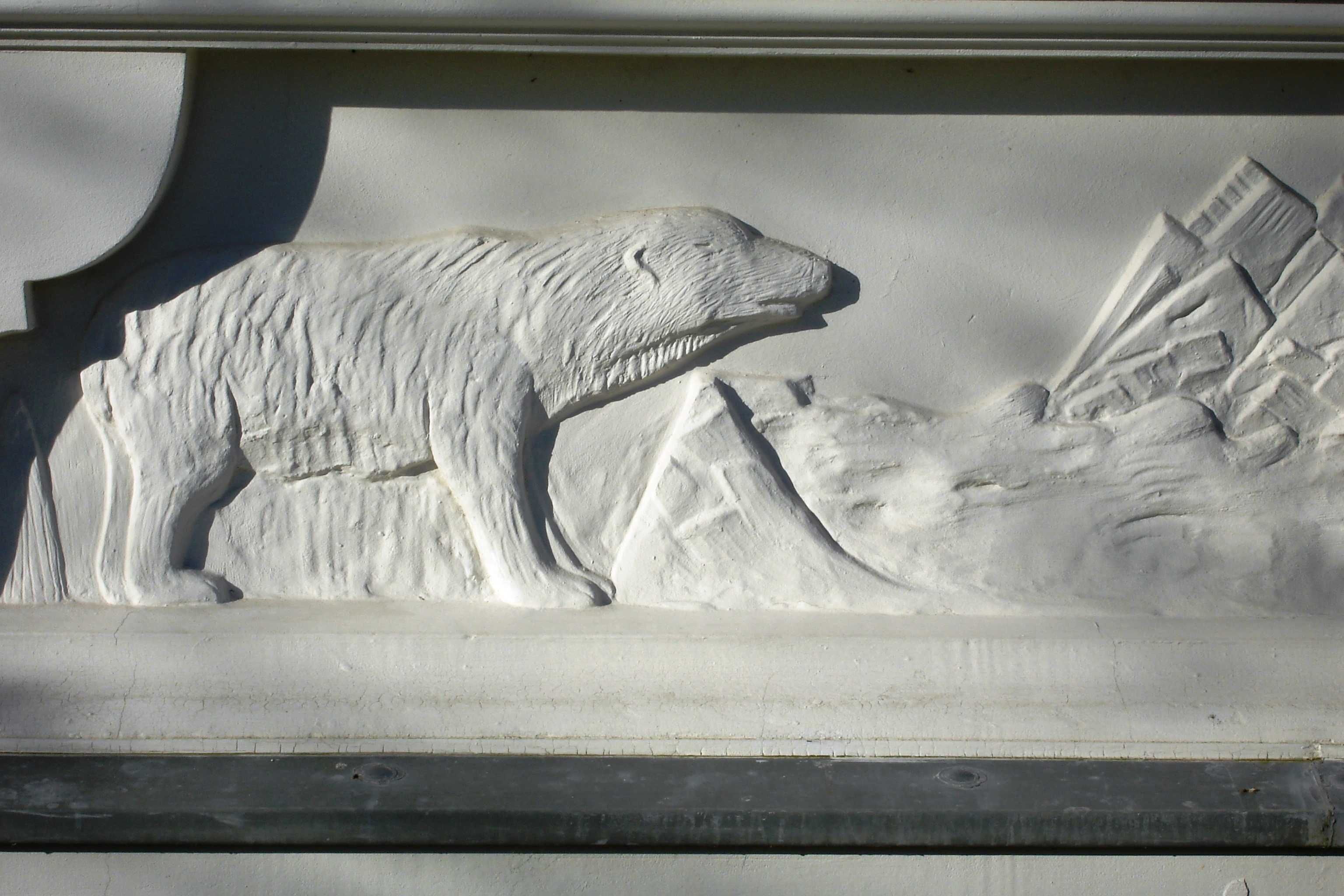 Eine Eisbärenskulptur vor einer Berglandschaft.