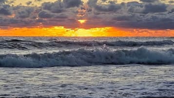 Ein Sonnenuntergang über dem Meer mit Wellen.