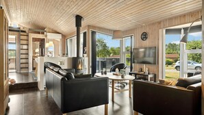 A modern living room with a fireplace, a TV, and a dining area.