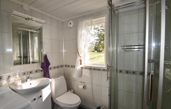 Une salle de bain avec des toilettes, un lavabo et une douche.