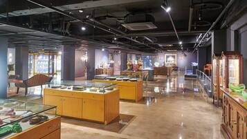 A museum interior with glass display cases, wooden cabinets, and various artifacts.