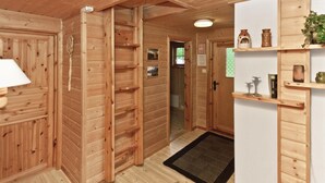 Ein Holzinterieur mit einer Holzleiter, einem schwarzen Teppich und Regalen mit Dekorationen.
