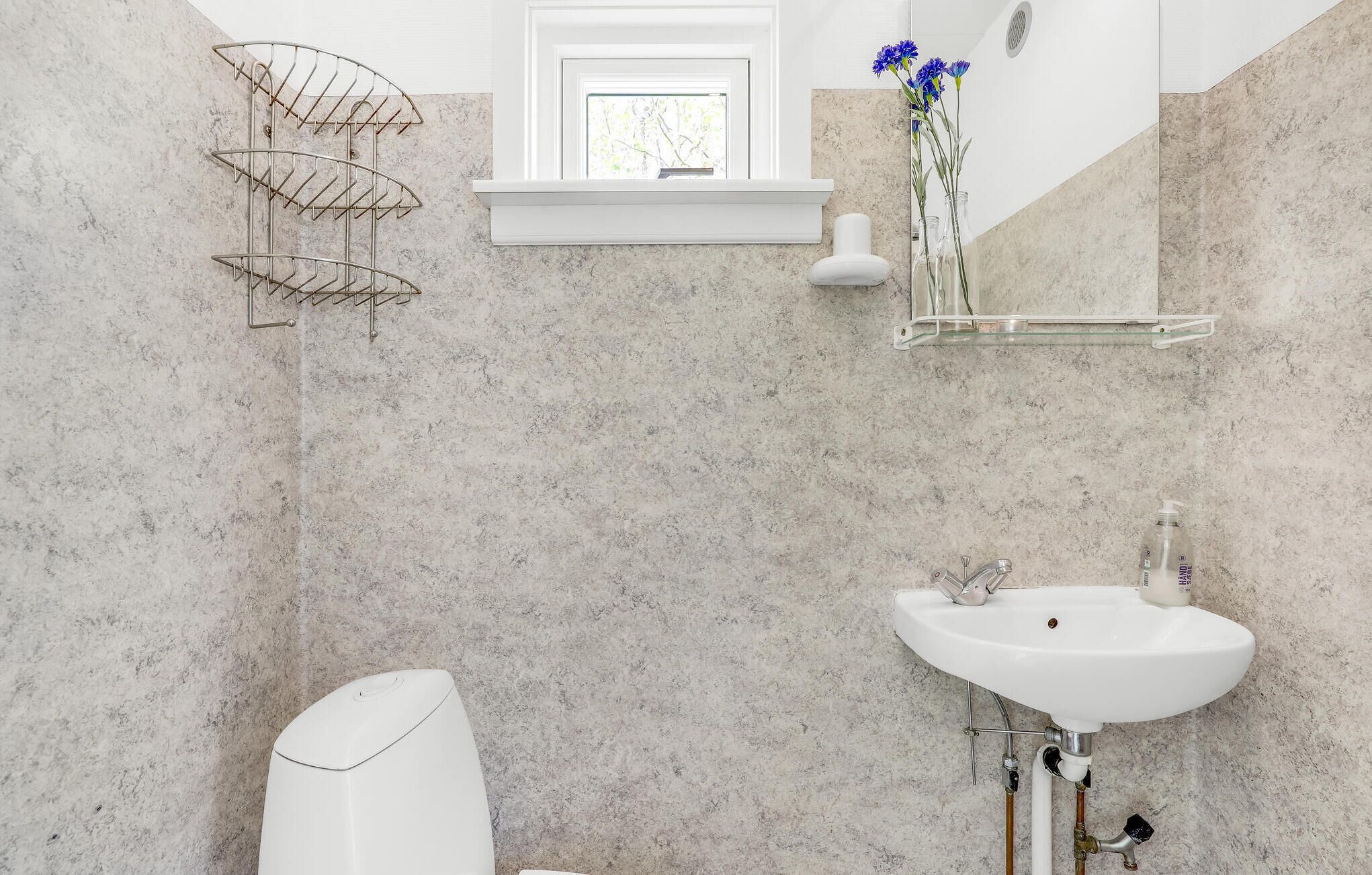 A bathroom with a white sink, a towel rack, and a mirror.