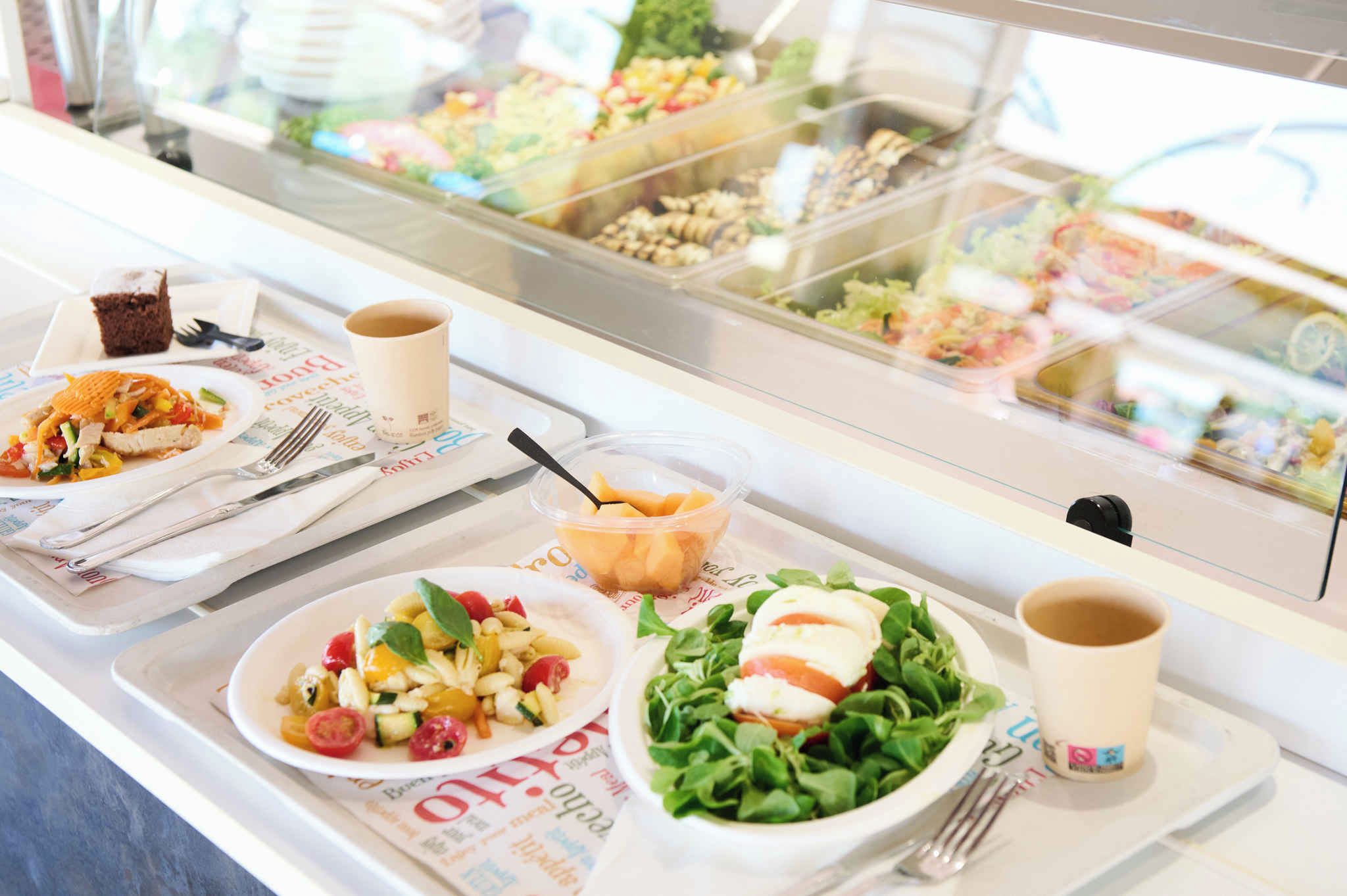 Un buffet con diversi piatti, tra cui insalate, dessert e bevande.