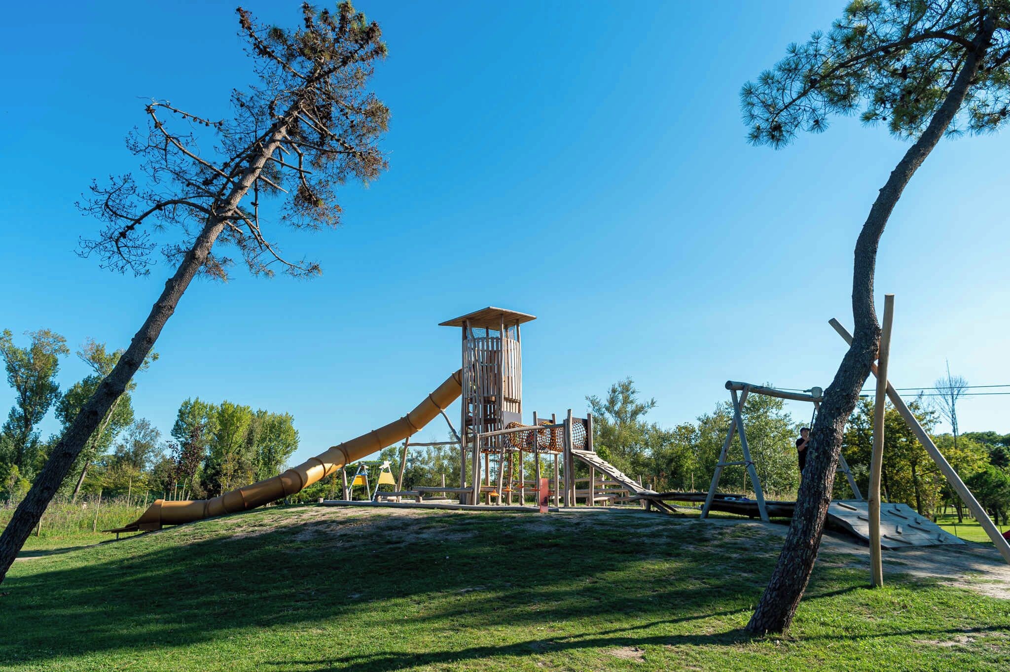 A playground with a slide, climbing structures, and a lookout tower.