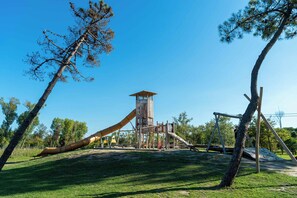 A playground with a slide, climbing structures, and a lookout tower.