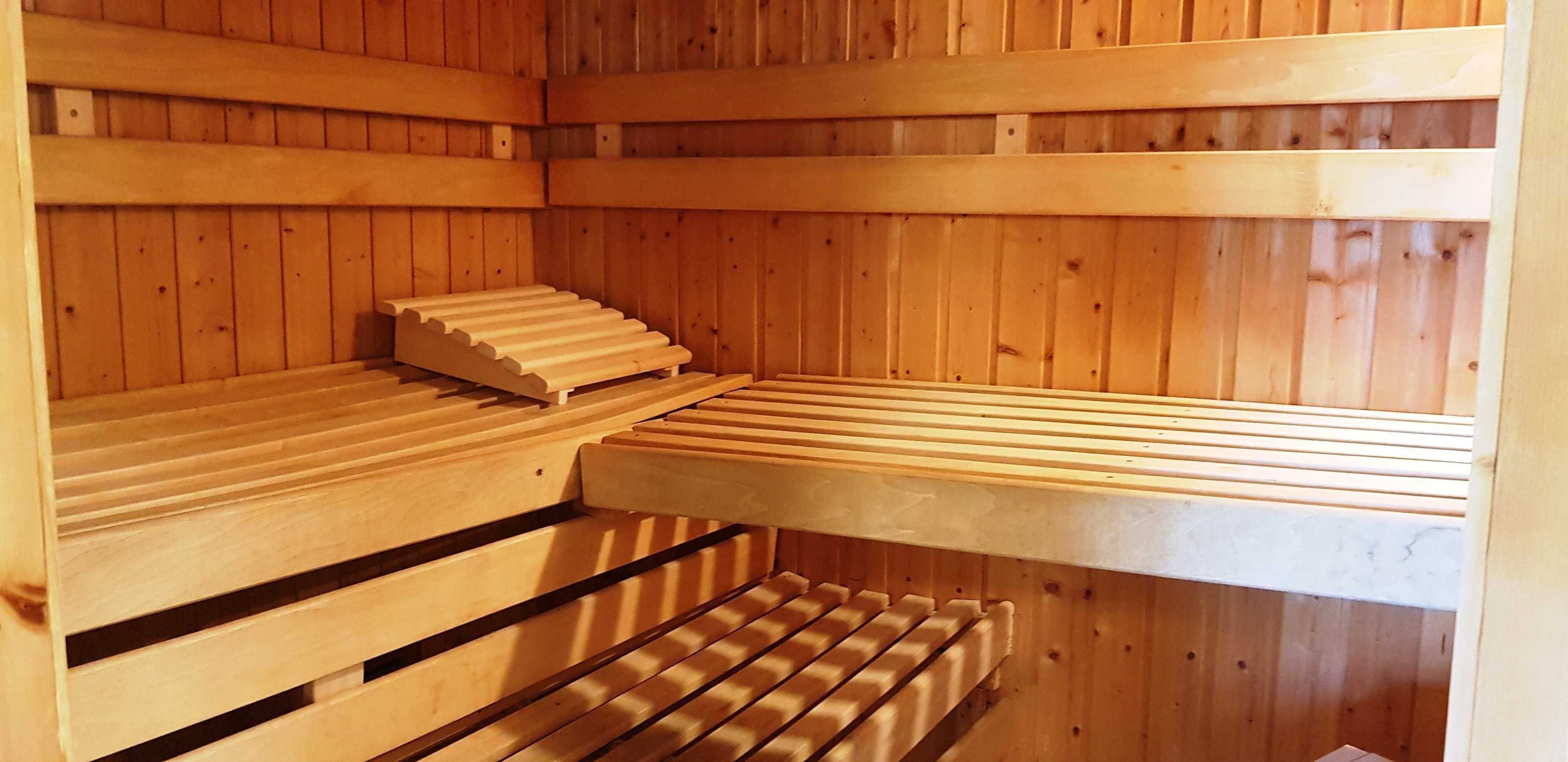 A sauna with wooden benches and a sloped floor.