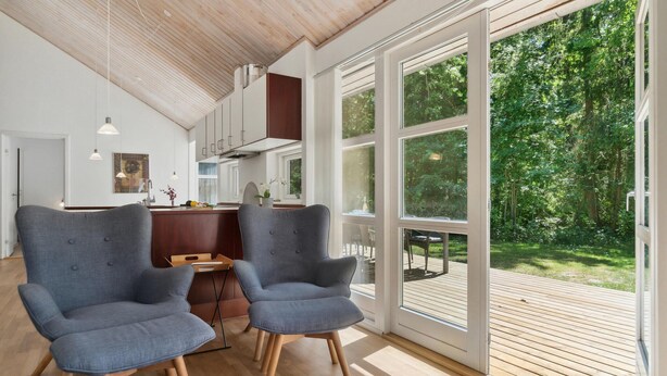 A modern kitchen with wooden cabinets and a large window overlooking a lush garden. - Stunning home in Hasle with sauna (Hasle)