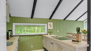 Eine Küche mit Fenster, grünen Wänden und einer Holz Arbeitsplatte.