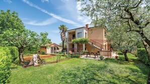 A two-story house with a stone facade, a balcony, and a garden with a pergola. - Beautiful apartment in Umag with WiFi (Umag)