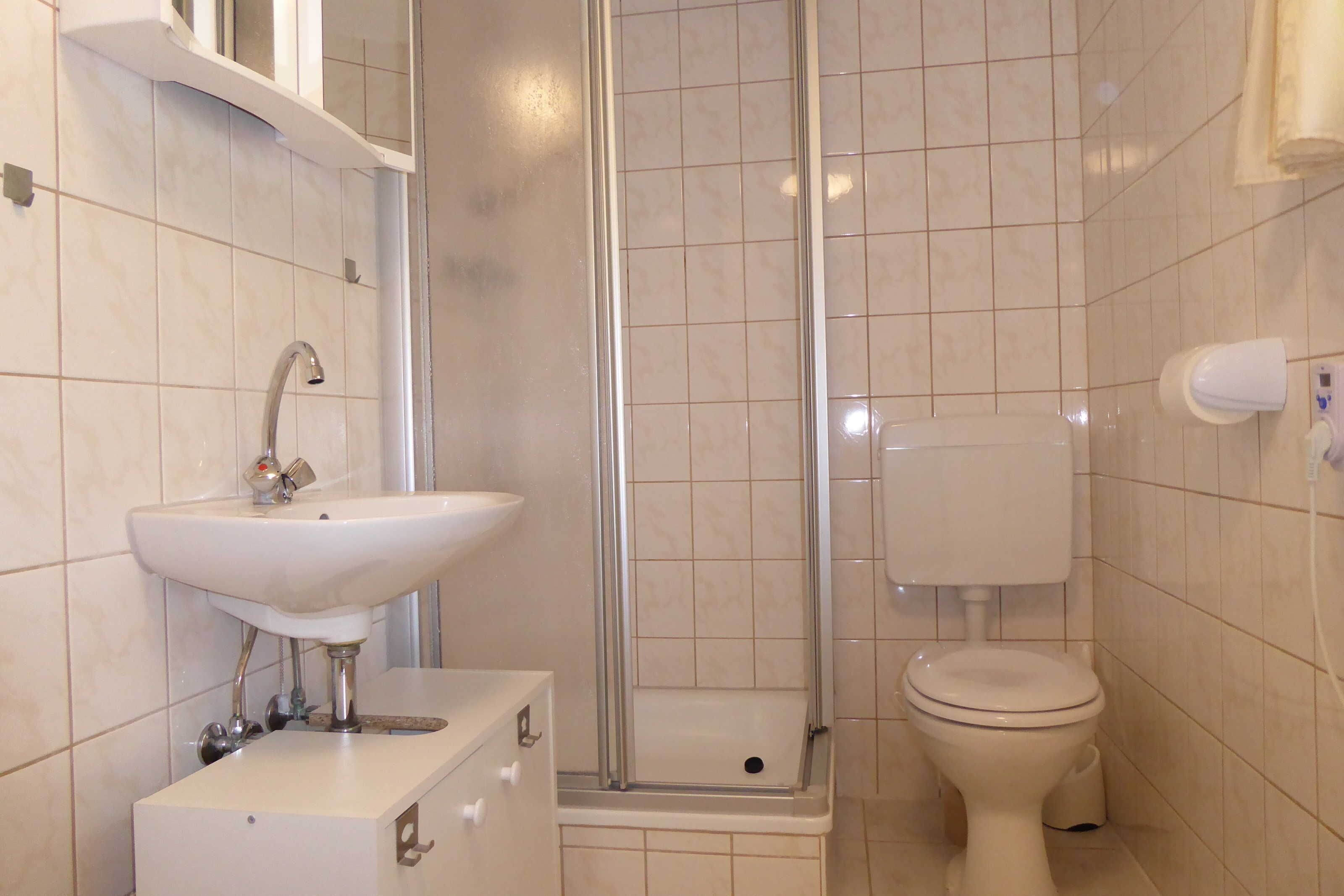 Ein Badezimmer mit Waschbecken, Toilette und Duschkabine.