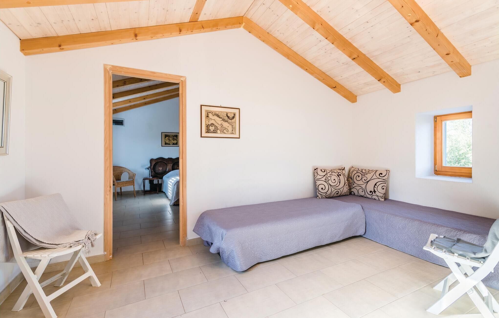 Une pièce confortable avec un lit, une chaise et une fenêtre.