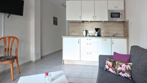 A compact living space with a kitchenette, a dining area, and a seating area.