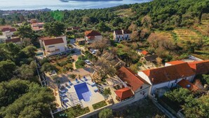 An aerial view of a coastal village with houses, a swimming pool, and a view of the sea. - Beach front home in Orebic (Orebic)