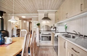 Et moderne køkken med træskabe, en stålkogeplade, mikroovn og vask.