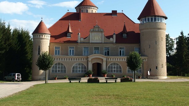 Un grand bâtiment historique doté de nombreuses tours et d’une entrée centrale.