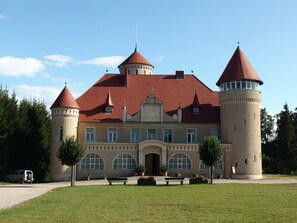 A large, historic building with multiple towers and a central entrance.