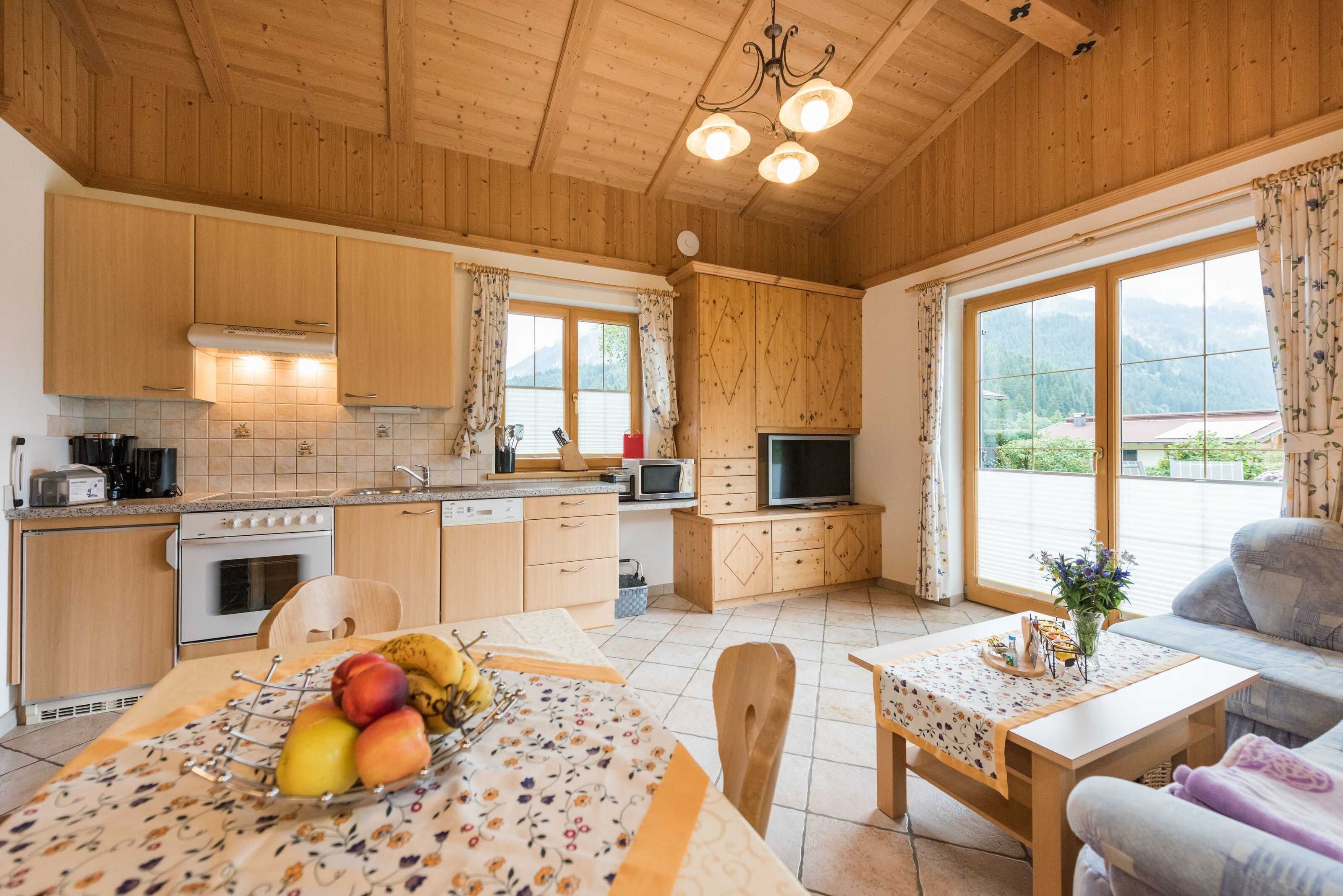 A wooden interior with a kitchen, dining area, and a sofa.