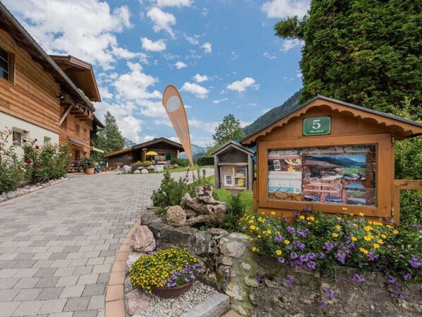 A wooden lodge with a stone pathway leading to a signpost.
