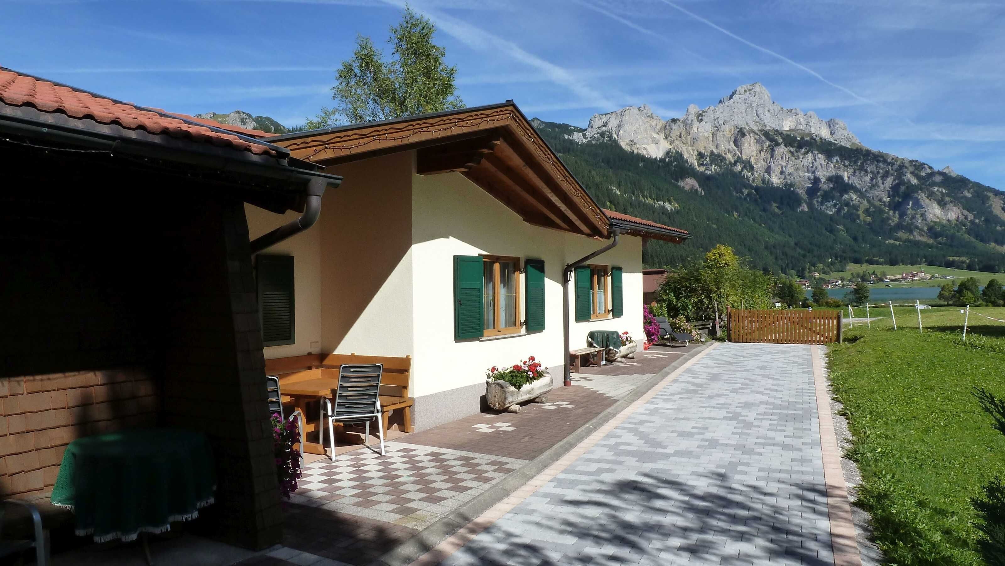 A house with a patio, outdoor seating, and a mountain view.