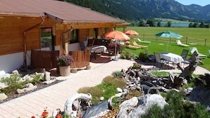 Ein Holzhaus mit Außenplätzen und Blick auf die Berge.