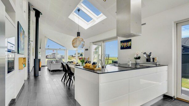 A modern kitchen with a large island, skylights, and a view of the outdoors. - Cozy home in Sæby with house sea view (Sæby)