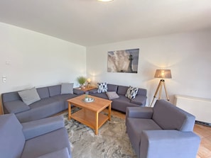 A modern living room with a sectional sofa, a wooden coffee table, and a floor lamp.