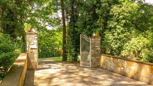 A gated entrance with stone pillars and a metal gate, surrounded by lush greenery. - Nice home in Camaiore LU (Camaiore LU)