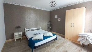 A bedroom with a bed, a nightstand, a wardrobe, and a shelf with a cat. - Gorgeous home in Lavardac with kitchen (Lavardac)