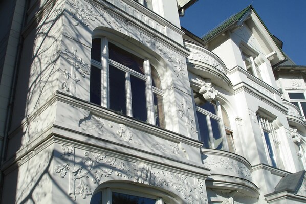 A building with ornate architectural details, including carved floral patterns and a prominent window.