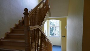 Una escalera de madera con barandilla que conduce a una plataforma.