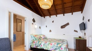 A bedroom with a bed, a desk, a chair, and a television. - La casita de la playa with jacuzzi (Santa Cruz de Tenerife)