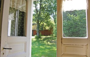 A door leading to a yard with a wooden fence and trees. - Stunning home in Lönashult with kitchen (Lönashult)