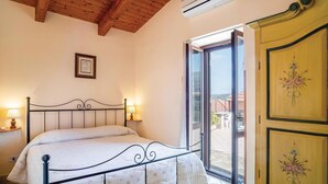 A bedroom with a bed, bedside lamps, a wooden wardrobe, and a window with a view. - 2 bedroom amazing home in Perdifumo SA (Perdifumo SA)
