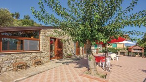 A stone building with wooden shutters, a tiled patio, and outdoor seating. - 2 bedroom amazing home in Perdifumo SA (Perdifumo SA)