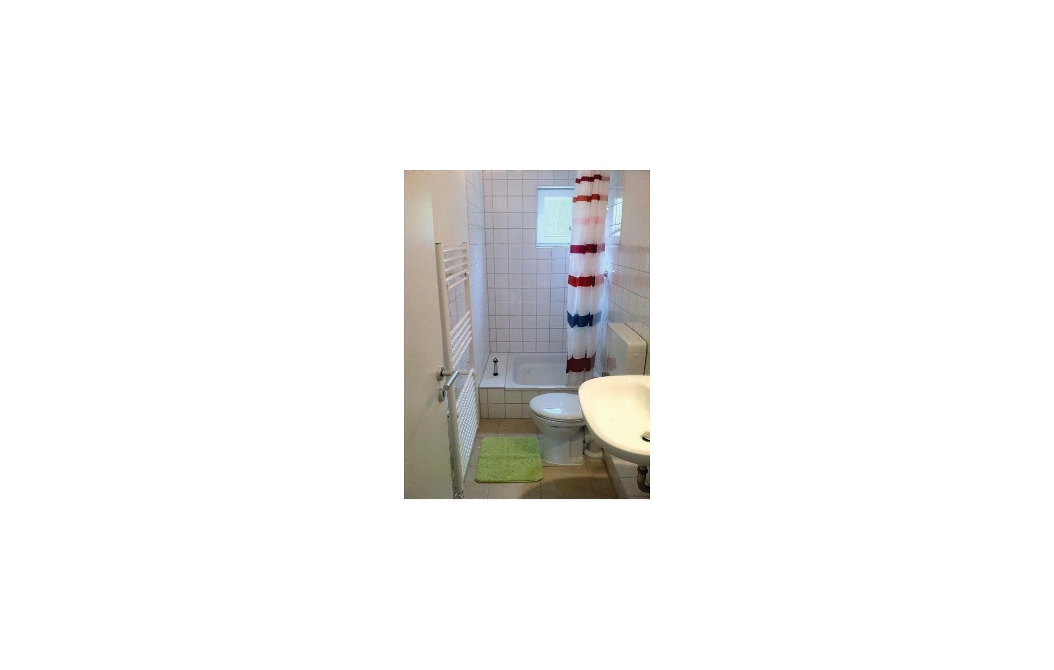 Une petite salle de bain avec des toilettes, un lavabo et une baignoire.