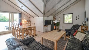 Un grand espace de vie comprenant une table à manger en bois, un canapé et un téléviseur.