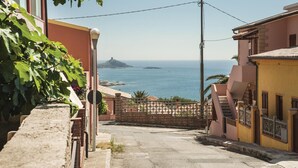 Eine enge Straße mit Blick auf das Meer und eine entfernte Insel.