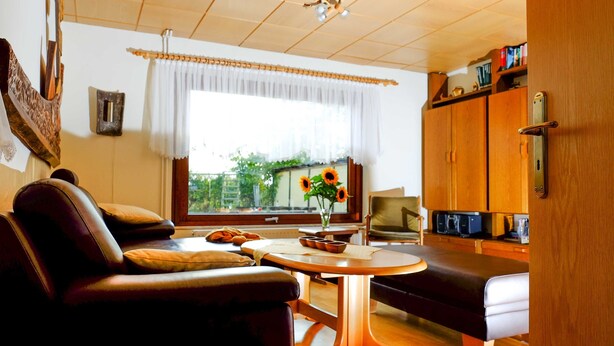 Uma sala de estar acolhedora com um sofá, uma mesa de centro e uma televisão.