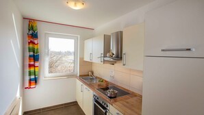 Una cocina moderna con ventana, electrodomésticos de acero inoxidable y encimera de madera.