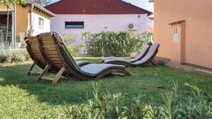 Twee lounge stoelen in een gazon met een gebouw op de achtergrond.