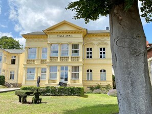 Villa Anna, a large, yellow building with a symmetrical facade, multiple windows, and a central entrance.
