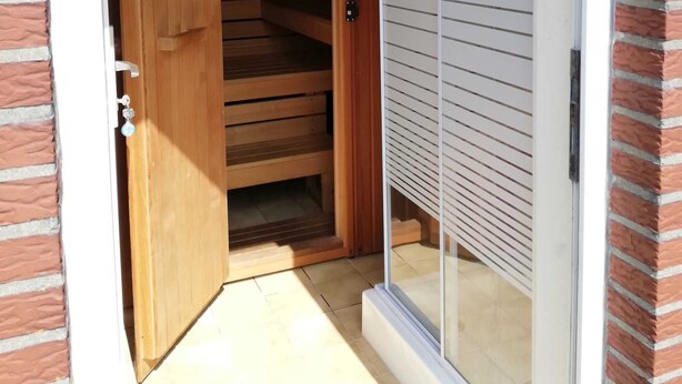 Una porta in legno che dà su una scala con una porta in vetro a destra.